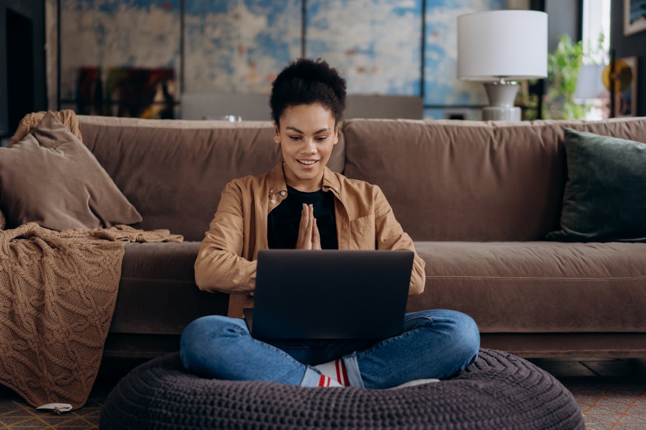 A woman sitting cross legged with a laptop.