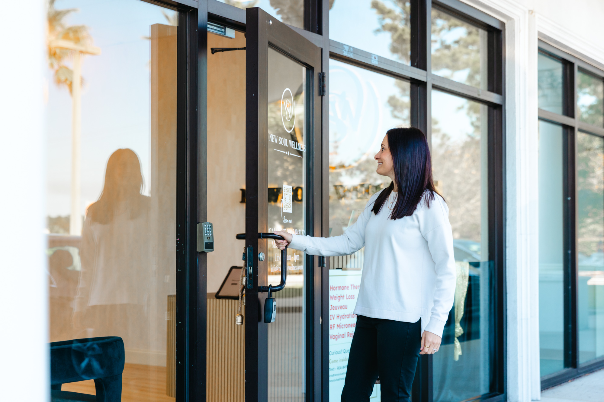woman in white sweater walking into New Soul Wellness